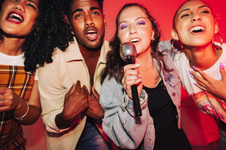 Vibrant friends singing together on karaoke night